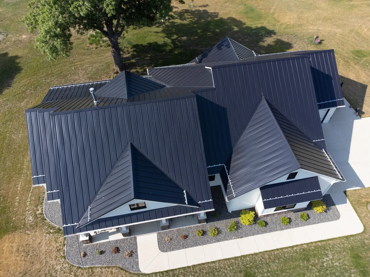 Aerial view of a home with a dark standing seam metal roof