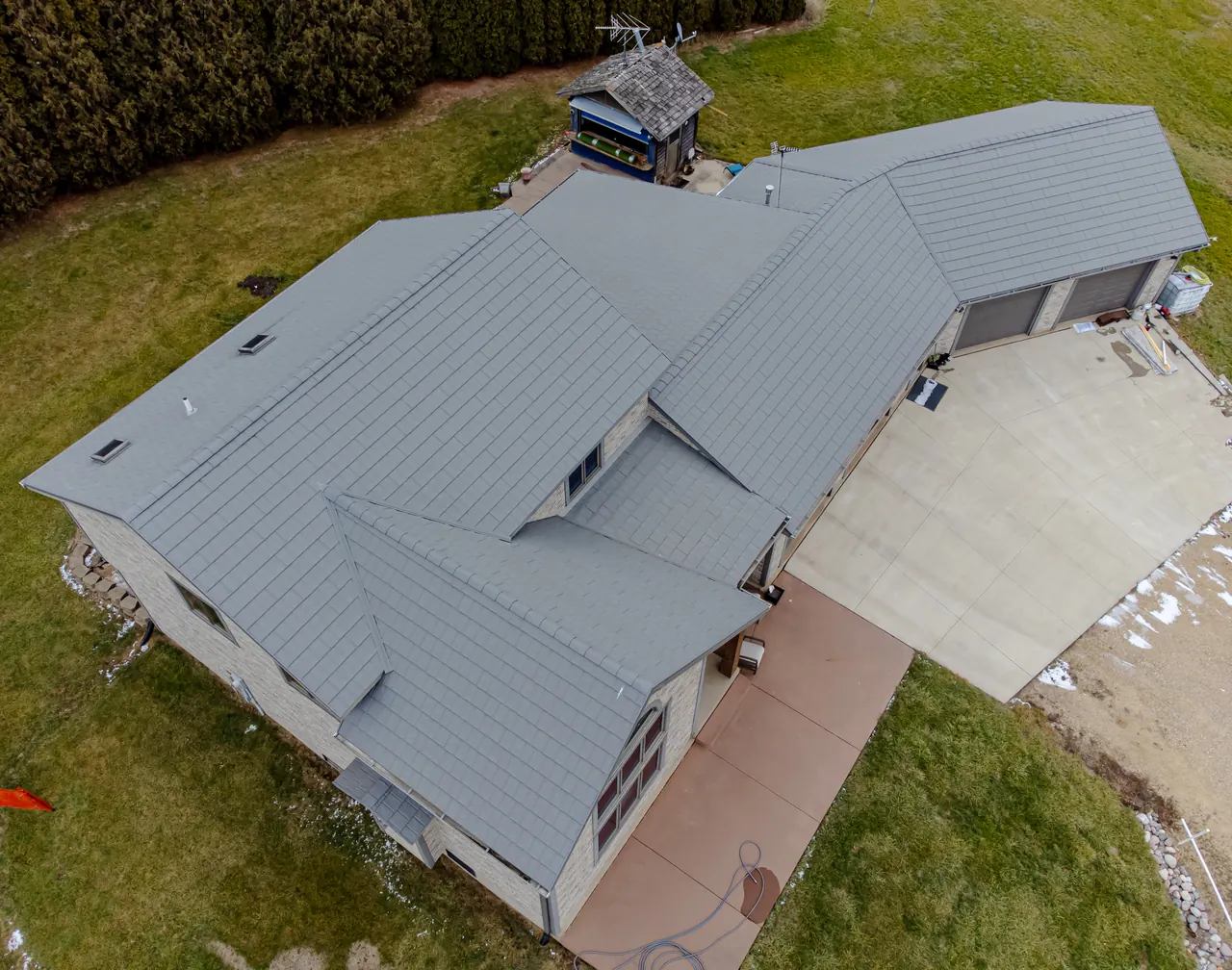 Aerial view of a house with a gray metal roof and attached garage